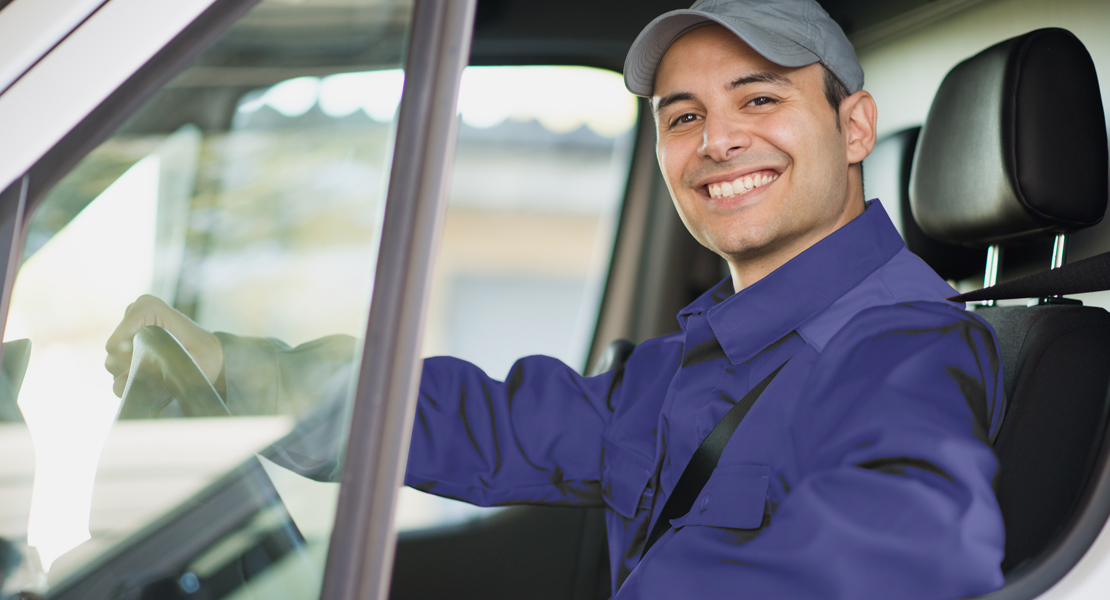 A man smiles while sitting in a van.