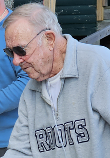 Man wearing sunglasses a grey roots sweatshirt and Oxygen tubing